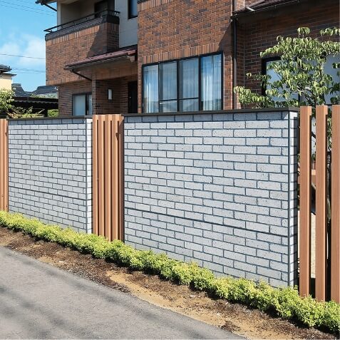 ブロック塀風に見せるエバーアートボードに、木目調の格子がアクセントに